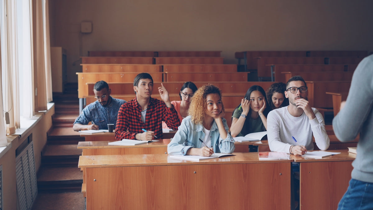 Students raising hands in a lecture hall