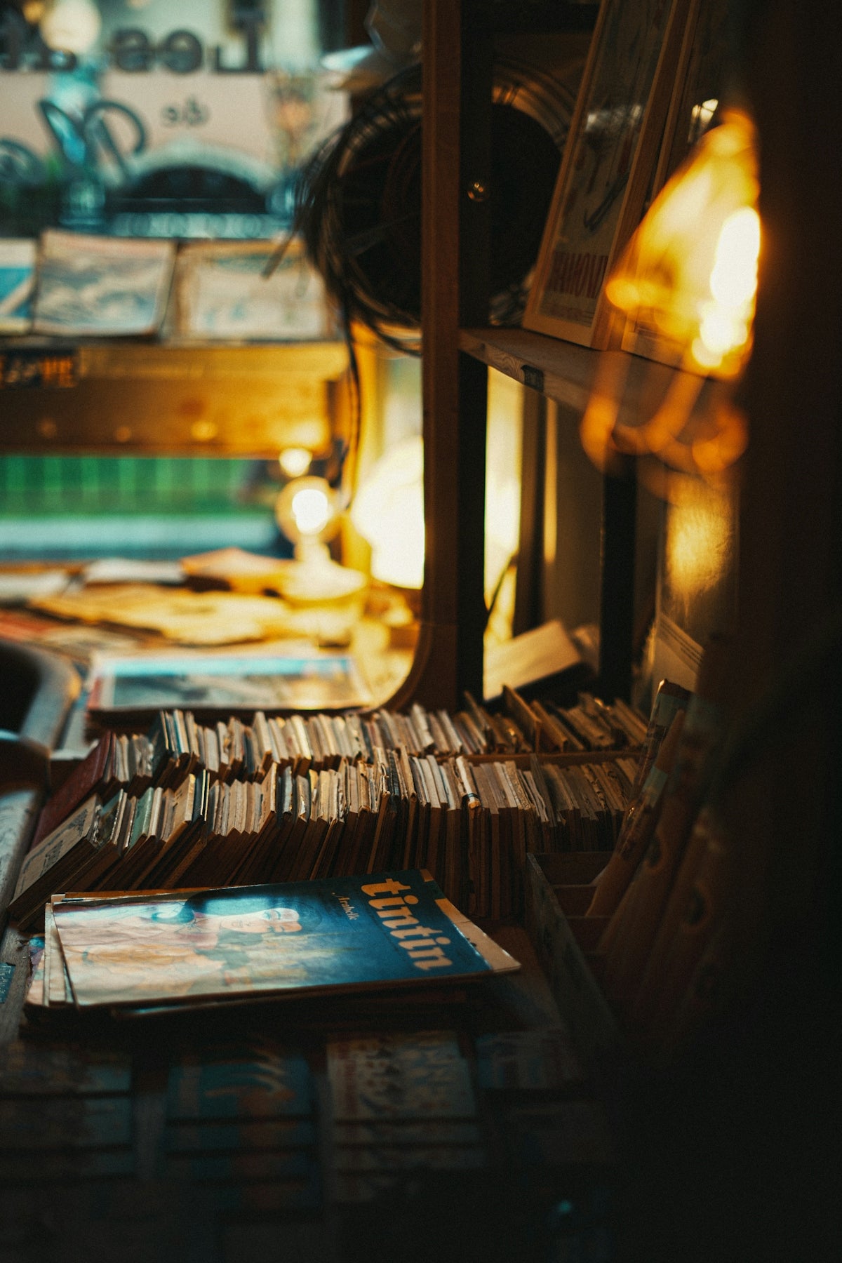 Stacks of old books and magazines on a shelf.